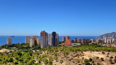 Canlı bir kıyı şehrinin nefes kesen ve çarpıcı manzarası. Yüksek binalar ve yemyeşil alanlar.