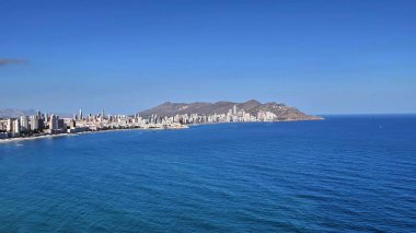 Berrak gökyüzü ile berrak mavi bir okyanusun yanında güzel bir kıyı şehrinin nefes kesici ve çarpıcı manzarası.