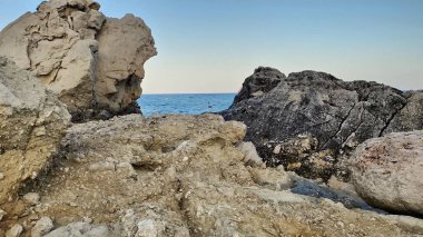 Kıyı boyunca kayalık oluşumlara sahip güzel ve sakin bir deniz manzarası ve açık bir okyanus manzarası sağlar.