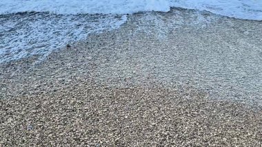 Yumuşak okyanus dalgaları eşsiz dokular ve büyüleyici desenlerle süslenmiş kumlu güzel bir sahili hafifçe okşuyor.