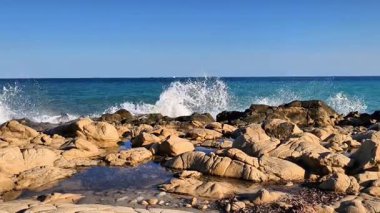 A stunning and picturesque coastal scene showcasing vibrant, deep blue waters alongside rugged, rocky shorelines