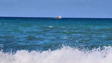 Uçsuz bucaksız okyanusun nefes kesici sakin manzarası. Huzurlu dalgaların arasında yavaşça sallanan küçük bir tekne.