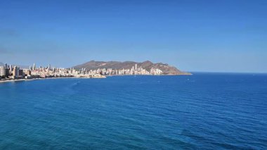 Benidorm 'un göz kamaştırıcı ufuk çizgisini, güzel, parıldayan sularıyla birlikte gösteren nefes kesici bir kıyı manzarası.