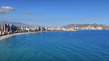 Parlak bir sahil şehrinin göz kamaştırıcı manzarası kristal berrak sularıyla kumlu sahil boyunca güzelce yerleşmiş.