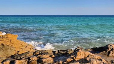 A tranquil scene of stunning blue waters crashing against rugged coastlines, perfect for nature enthusiasts