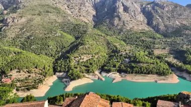 Göz kamaştırıcı bir turkuaz göl bu nefes kesen manzarada gür, yüksek dağlarla güzel bir şekilde çevrilidir.