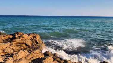 Beautiful coastal scene with clear blue water and rocky shoreline, capturing the essence of maritime nature.