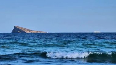 A breathtaking coastal scene showcasing a rocky island beautifully set amidst the shimmering blue waters of the ocean