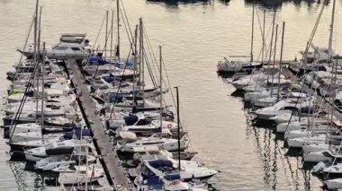 Havadan çekilen görüntüler, sakin ve ışıltılı sulara kenetlenmiş tekne ve lüks yatlarla dolu yoğun bir marinayı gösteriyor.