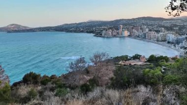 Gün batımında güzel bir sahil kasabasının yanındaki sakin suların nefes kesici ve çarpıcı manzarası