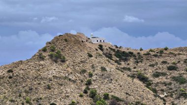 Enjoy a breathtaking hilltop view showcasing a historic structure, gracefully surrounded by natural terrain