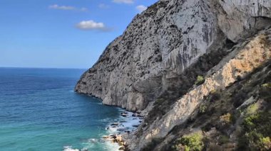 A breathtaking and stunning view of rocky cliffs and incredibly turquoise waters under a bright, clear sky