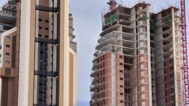 Gökyüzüne karşı kurulmuş modern gökdelenlerin sürmekte olan inşaatı ve gelişimini gözler önüne seriyor