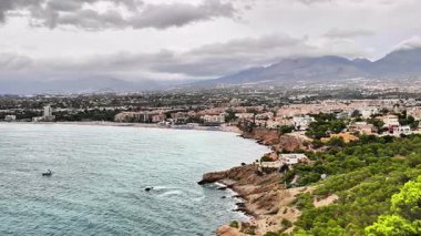 A breathtaking coastal panorama beautifully showcasing rolling hills, fluffy clouds, and the serene waters of the ocean