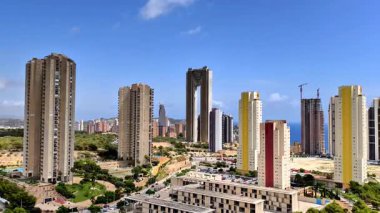 Canlı bir şehir manzarasının nefes kesici bir perspektifi yemyeşil, yemyeşil bir ortamda uzun gökdelenler sergiliyor.