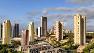 Güzel bir şekilde sergilenen canlı bir şehir manzarası yemyeşil alanların yanındaki binaları yükseltiyor.