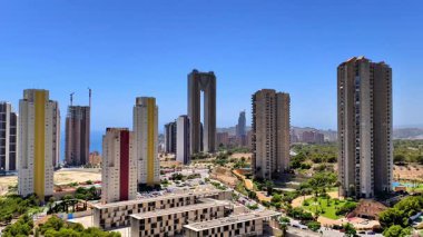 Canlı bir ufuk çizgisi, yeşillikle harmanlanmış modern kulelere ve çarpıcı kıyı manzaralarına sahip.