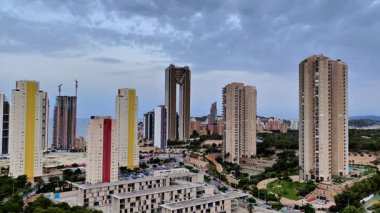 Görsel olarak çarpıcı bir kentsel ufuk çizgisi sergileniyor zarif modern binalar güzel bulutlu gökyüzünün arka planına kuruluyor.