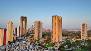 Sıcak akşam ışığında güzelce yıkanan çağdaş gökdelenlerin nefes kesici manzarası.