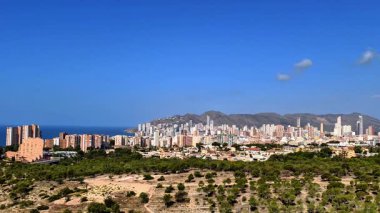 Sersemletici ve nefes kesici Benidorm ufuk çizgisini deneyimleyin, yemyeşil ve parlak gökyüzü ile çevrili