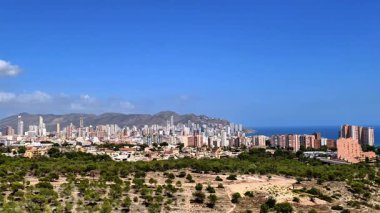 Benidorm 'un nefes kesici manzarasına dikkatle bakın. Huzurlu denize karşı çarpıcı ve ikonik siluetini gururla sergiliyor.