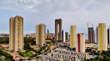 Nefes kesen şehir silueti verimli yeşilliklerle çevrili modern yüksek binaların büyüleyici bir görüntüsünü gözler önüne seriyor.