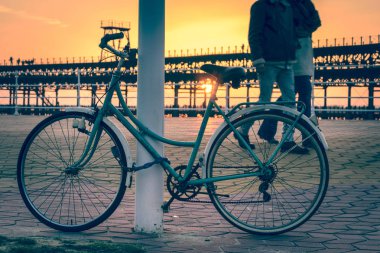 Güneş batarken bir çift bir vintage Bisiklet Huelva İspanya Rio Tinto rıhtımın yanında elini kolunu sallaya dönüyor