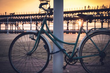Arka planda bir günbatımı ile Rio Tinto dock, vintage Bisiklet Huelva, Endülüs, İspanya direğine bağlı kalır