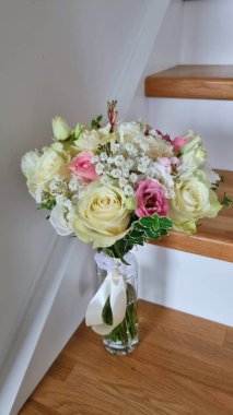 Ahşap merdivenlerde arka plan olarak beyaz ve pembe renkli düğün buketi. Çiçek salonu konsepti, tebrik kartları ve güzellik salonları.