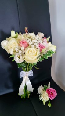 Düğün buketi masanın üstünde. Pembe ve beyaz bir yaka çiçeğiyle narin bir düğün buketi. 