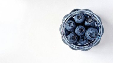 Düzgün beslenme ve diyet kavramı, beyaz arka planda böğürtlenli meyve cam vazosu.