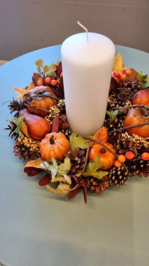 Yaratıcı dekorasyon için çelenk, kozalak, yaprak, balkabağı ve böğürtlen dolanıyor. İç mekan için mumlu tematik dekor.