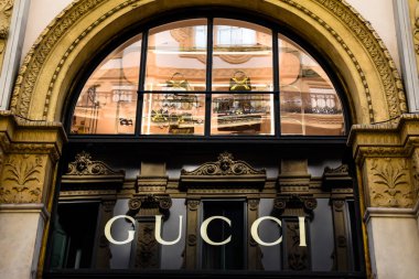 Milan, İtalya - 25 Mayıs 2018: Seçici odak Gucci dükkanı logosuna Galleria Vittorio Emanuele II ile arka planda, Milano, İtalya