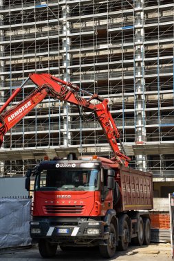 Milan, İtalya - 24 Mayıs 2018: Modern ekskavatör Kazı çalışmaları ve daha aptal kamyon, site bina sanayî Makinaları gerçekleştirir.
