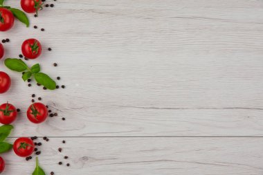 Domates fesleğen yaprakları ve beyaz tablo, kopya alanı, kara biber kiraz görünümü üst.