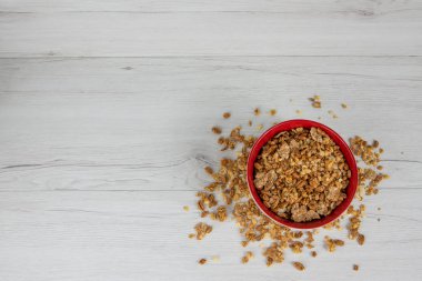 Granola Beyaz ahşap masa, üstten görünüm üzerinde tam kırmızı bir kase