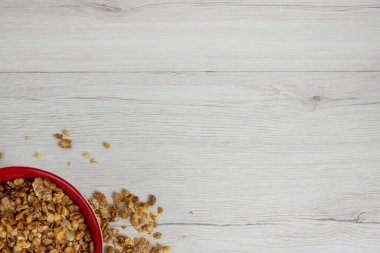 Beyaz ahşap masa, üstten görünüm, kopya alanı granola tam kırmızı bir kase