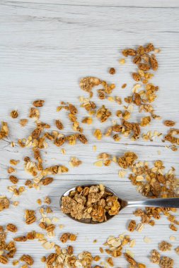 Beyaz ahşap masa, üstten görünüm üzerinde granola dolu kaşık