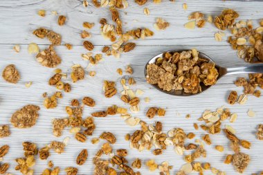 Beyaz ahşap masa, üstten görünüm üzerinde granola dolu kaşık