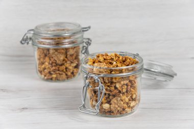 İki kavanoz granola Beyaz ahşap masa üzerinde dolu