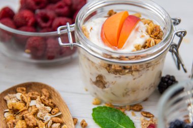 Kavanoz granola, yoğurt ve taze meyveleri ve tahta kaşık tam whit granola, yakın çekim, seçici odak ile tam