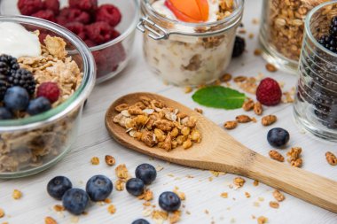 Kavanoz granola, yoğurt ve taze meyveleri ve tahta kaşık tam whit granola, yakın çekim, seçici odak ile tam