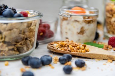 Kavanoz granola, yoğurt ve taze meyveleri ve tahta kaşık tam whit granola, yakın çekim, seçici odak ile tam