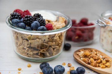 Kavanoz granola, yoğurt ve taze meyveleri ve tahta kaşık tam whit granola, yakın çekim, seçici odak ile tam