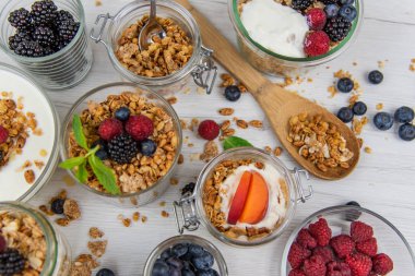 Granola, yoğurt ve taze meyveleri ve tahta kaşık tam whit granola, üstten görünüm seçici odak ile dolu kavanoz
