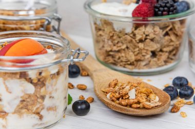 Kavanoz granola, yoğurt ve taze meyveleri ve tahta kaşık tam whit granola, yakın çekim, seçici odak ile tam