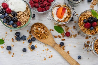 Granola, yoğurt ve taze meyveleri ve tahta kaşık tam whit granola, üstten görünüm seçici odak ile dolu kavanoz