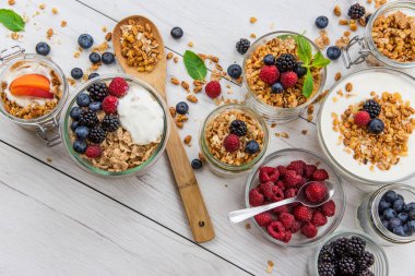 Granola, yoğurt ve taze meyveleri ve tahta kaşık tam whit granola, üstten görünüm seçici odak ile dolu kavanoz