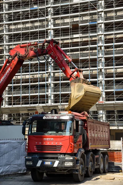 Milan, İtalya - 24 Mayıs 2018: Modern ekskavatör Kazı çalışmaları ve daha aptal kamyon, site bina sanayî Makinaları gerçekleştirir.