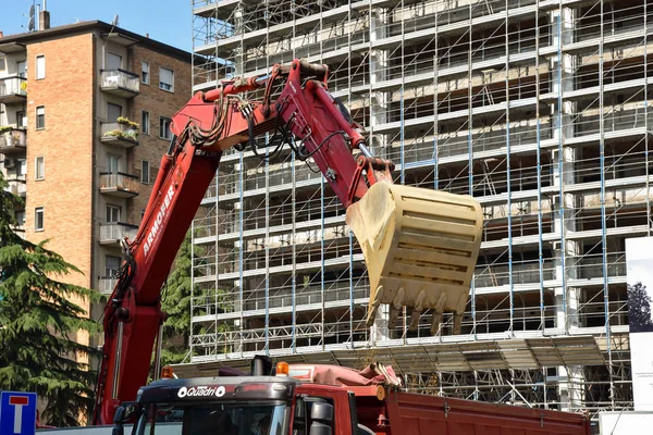 Milan, İtalya - 24 Mayıs 2018: Modern ekskavatör Kazı çalışmaları ve daha aptal kamyon, site bina sanayî Makinaları gerçekleştirir.